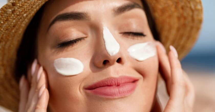 femeie aplica un produs cu SPF pe fata